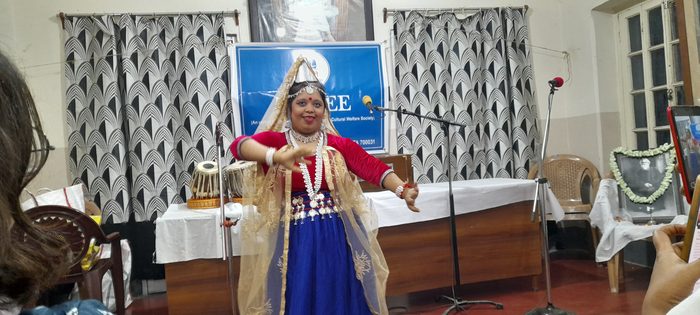 A dancer in costume performing in front of the TOREE banner.