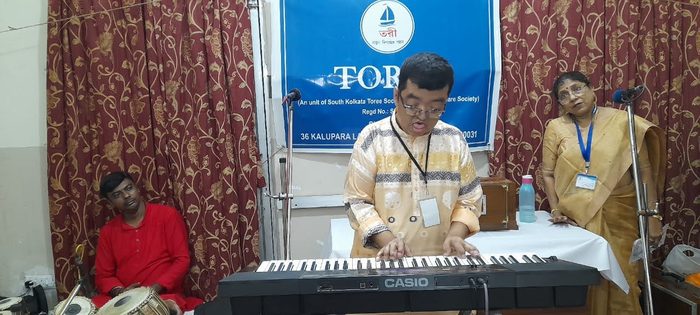 A young man playing a keyboard at a TOREE programme.