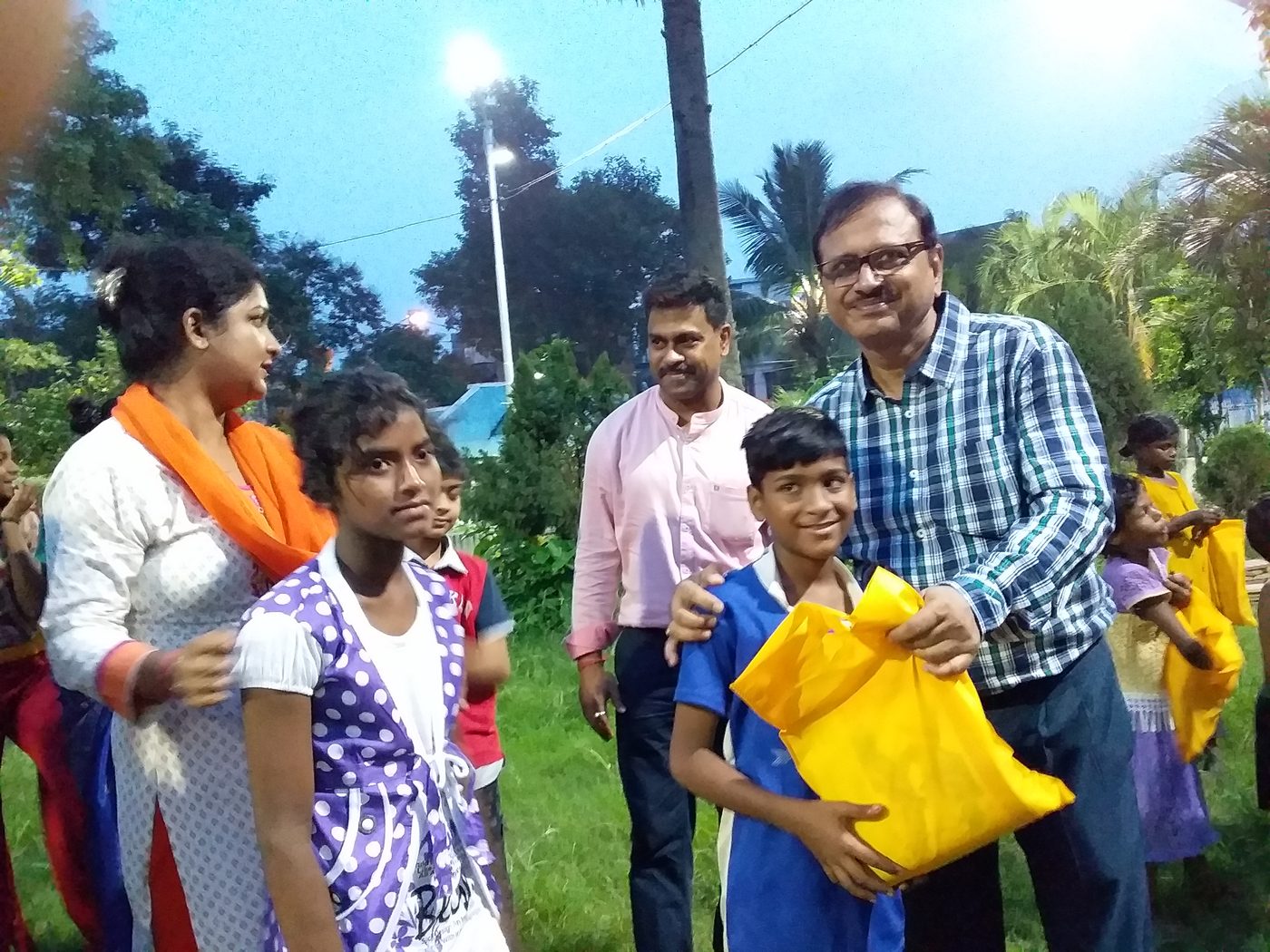 Members of TOREE handing gift bags to children at a celebration.