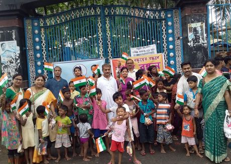 Children and volunteers holding flags at an Independence Day celebration in Kolkata.