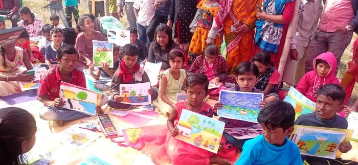 Children holding up their finished drawings at a sit-and-draw competition, January 2025.