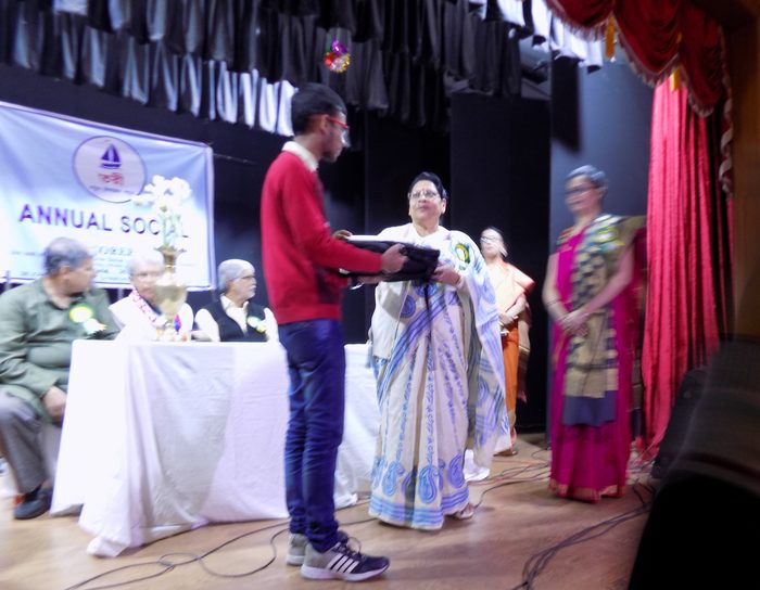 A student receiving the scholarship from a guest at the Annual Social.