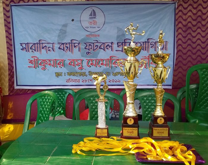 Trophies and medals laid out beneath the tournament banner, July 2019.