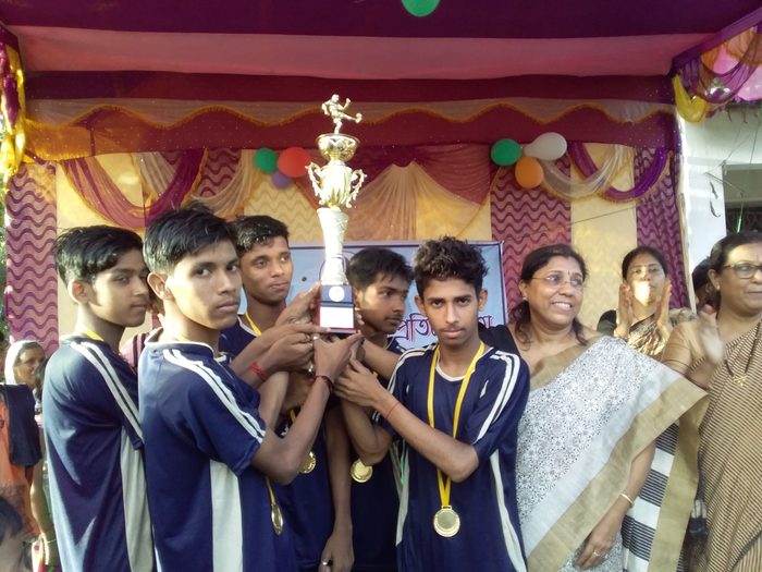 The winning team in jerseys and medals holding up their trophy, July 2019.