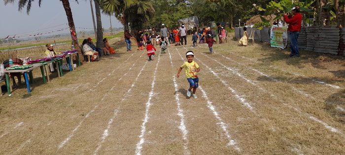 Children and members gathered by the prize table at the edge of the field.