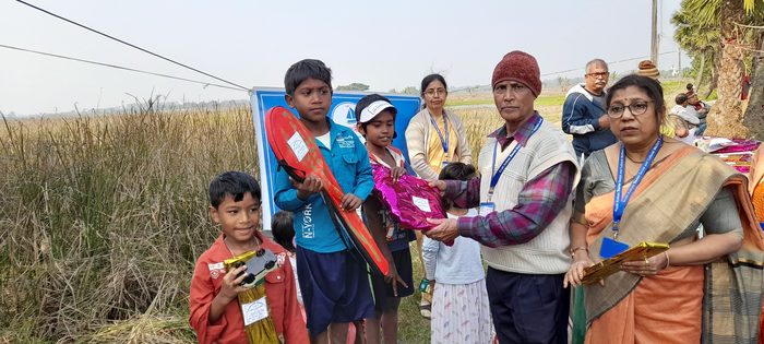 A boy receiving a prize from members of TOREE at the sports meet.