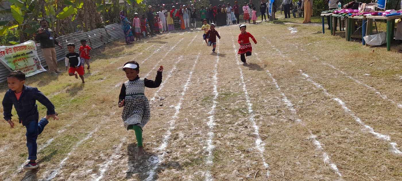 Children racing down chalk-marked lanes on an open field lined with palm trees.