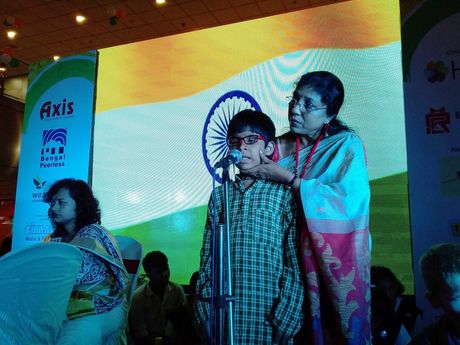 Visually impaired students singing on stage at an Independence Day programme.